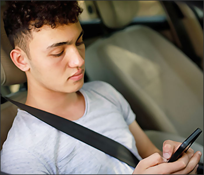 homme maghrebin textote au volant