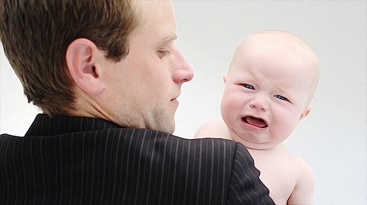 bebe pleure dans les bras de son pere