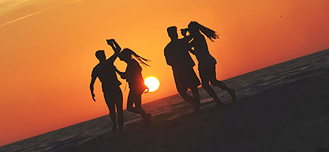 Vacances entre amoureux - Deux couples dansent sur la plage