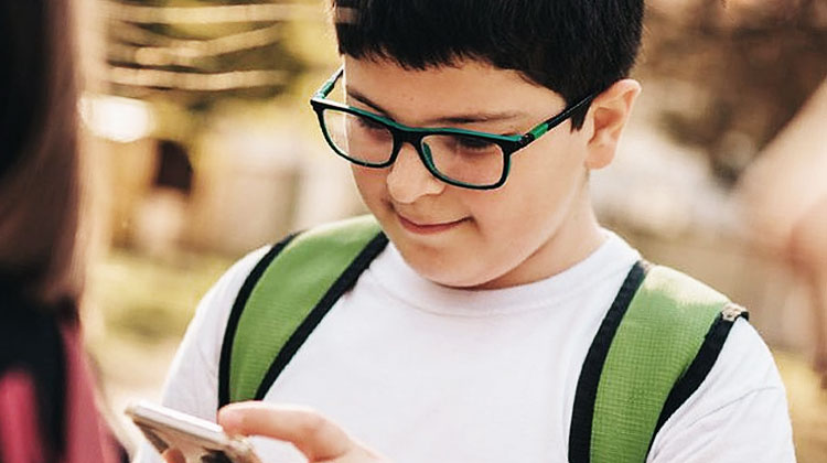 enfant a lunettes sur son telephone