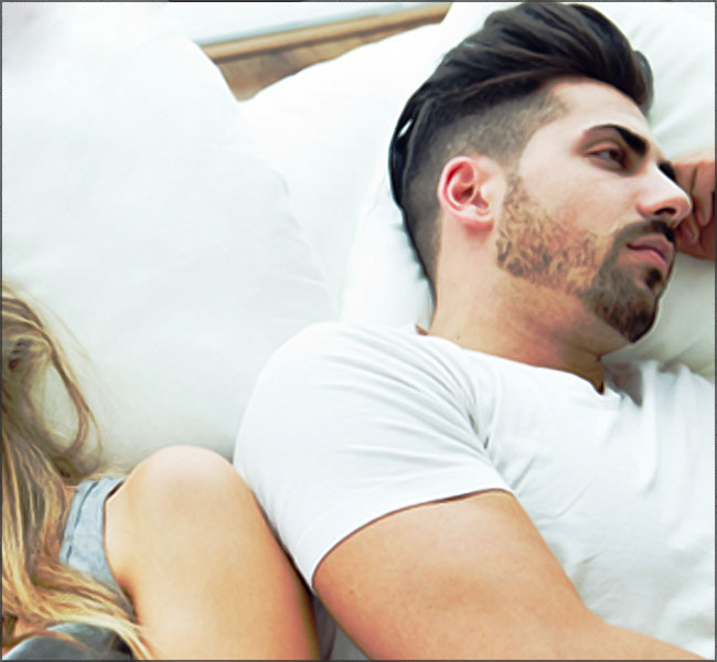 homme s ennuyant au lit a cote de sa femme ou copine