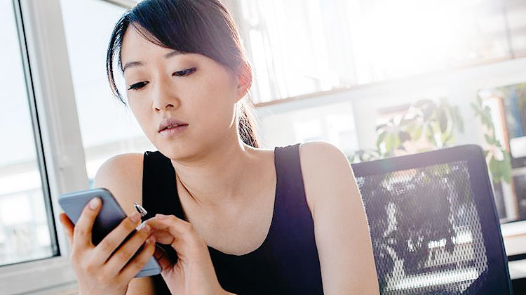 une employee sort son telephone au travail