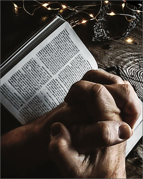 homme prie devant la bible