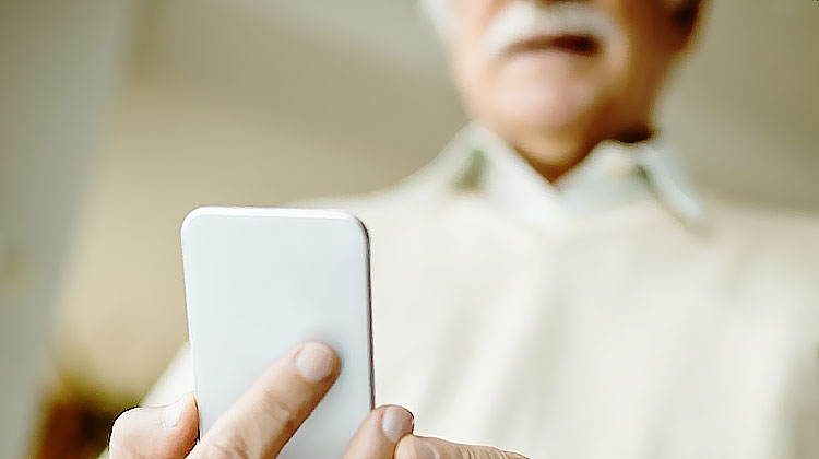 personne agee tenant un telephone mobile