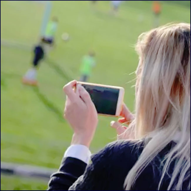 une femme enregistre un mach de football