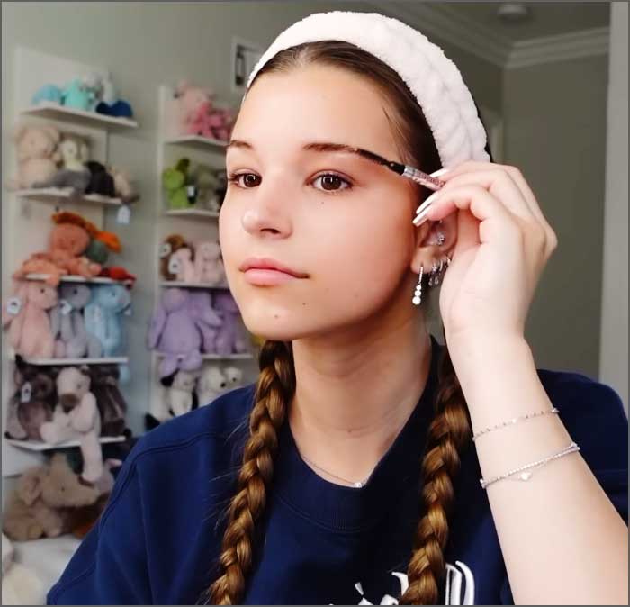 Jeune fille appliquant du maquillage dans sa chambre. (Brooke Monk)