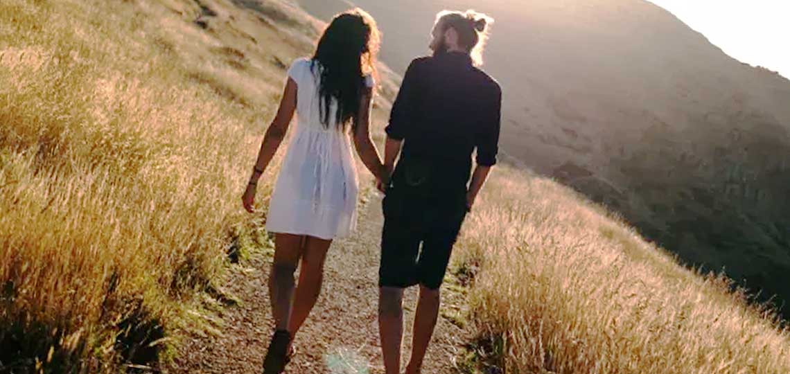 couple de fiances se promene sur un chemin