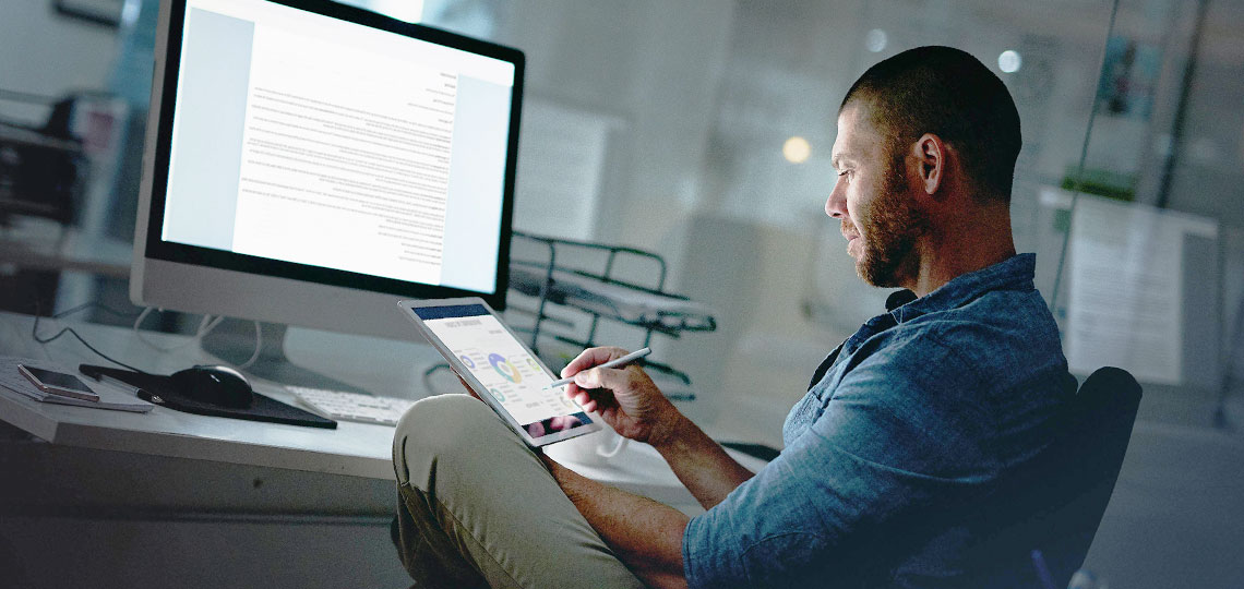 homme serein et protege devant son ordinateur et tablette