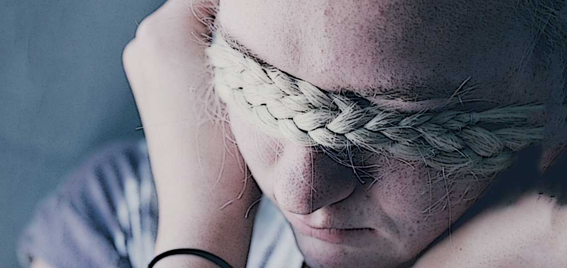 fillette se cache les yeux avec sa natte air triste