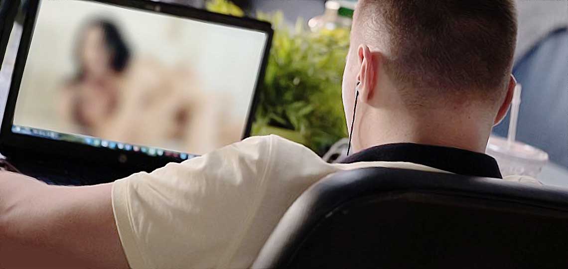 un jeune regarde une femme sur l ecran de son ordinateur portable