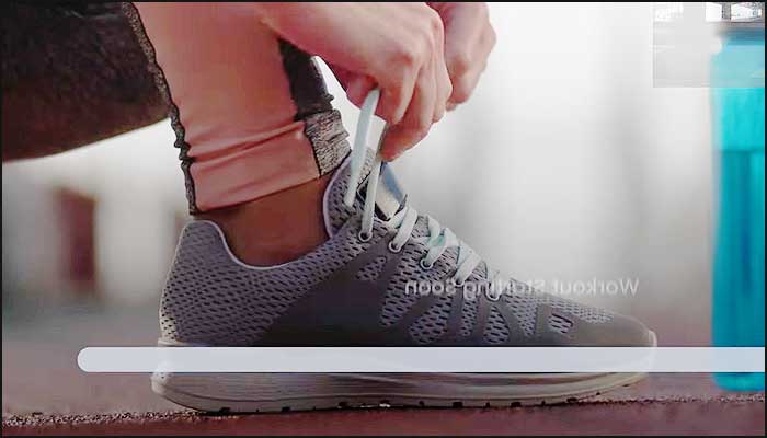 une femme noue ses lacets de baskets