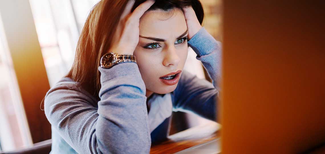 femme se prend la tete devant son ordinateur portable
