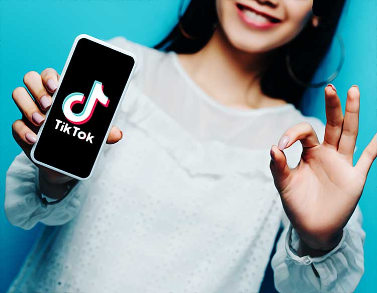 Personne montrant application TikTok sur smartphone.
